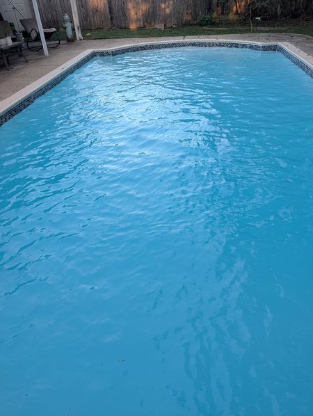 Rectangular pool with a blue mosaic tile line and clear blue water
